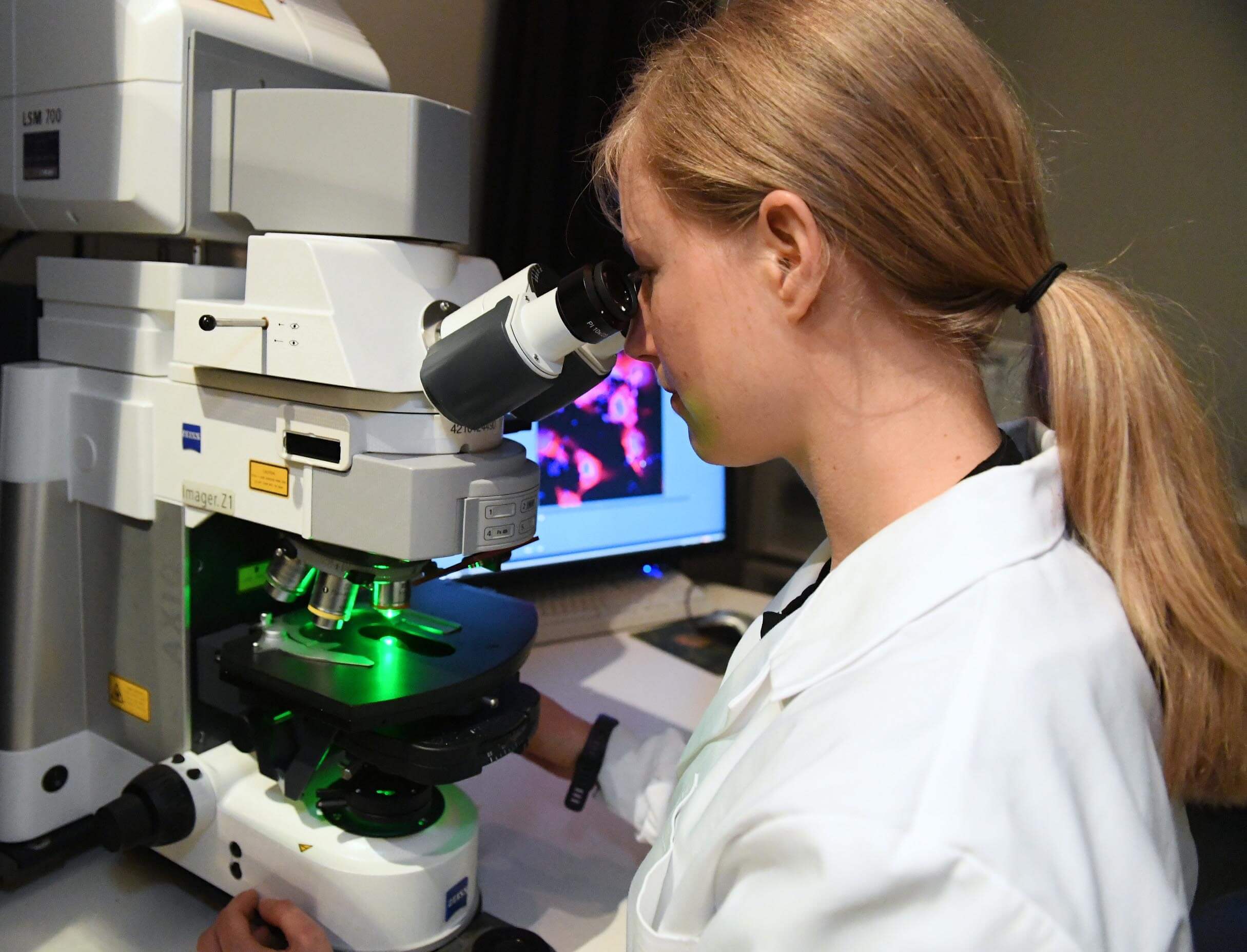 Female scientist looking through microscope